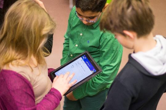 Das Foto zeigt drei Schüler*innen beim Spielen eines Parcours.